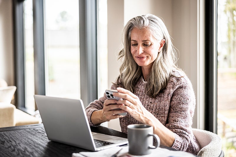 woman on phone and laptop